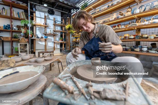 young woman artist making clay bowl on pottery wheel. - pottery wheel stock pictures, royalty-free photos & images