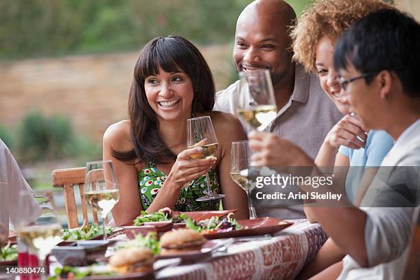 friends enjoying meal together outdoors - va summer party stockfoto's en -beelden