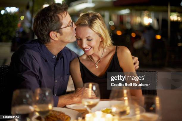 caucasian husband kissing wife in restaurant - couple in restaurant bildbanksfoton och bilder