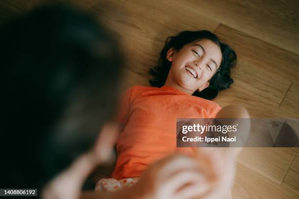 young girl having her feet tickled - kids feet in home stock-fotos und bilder