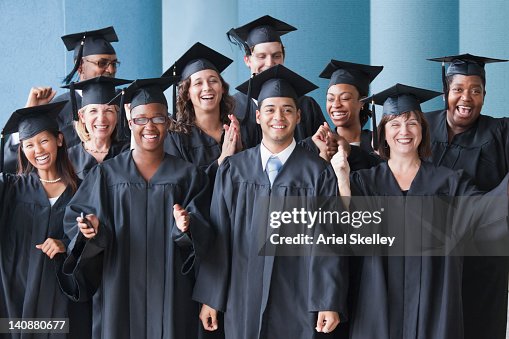College graduates cheering in caps and gowns College graduates cheering in caps and gowns
