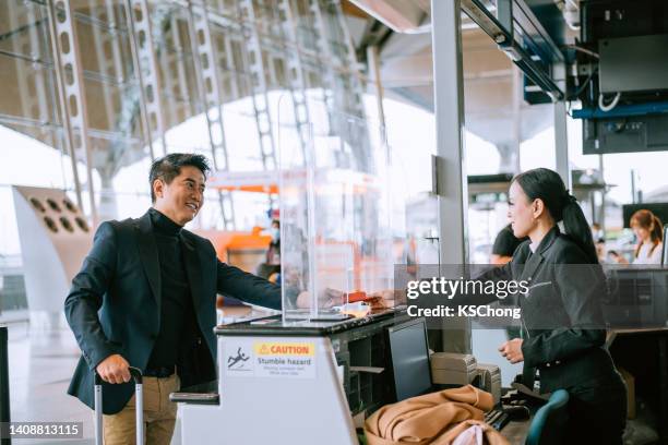 hombre de negocios en el mostrador de facturación del aeropuerto - security check fotografías e imágenes de stock