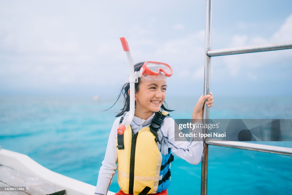 Young girl with snorkel mask on boat