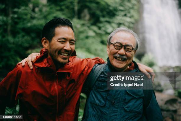 senior father and adult son having fun in forest in rain - asia rain stock pictures, royalty-free photos & images