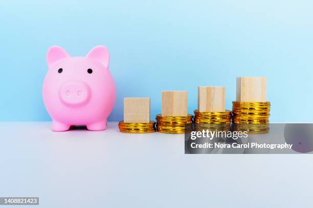 piggy bank with stack of coins and four wood block - 貯金箱 ストックフォトと画像