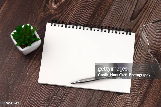 blank note pad with pen, eye glasses and potted plant - spiral notebook table stock pictures, royalty-free photos & images