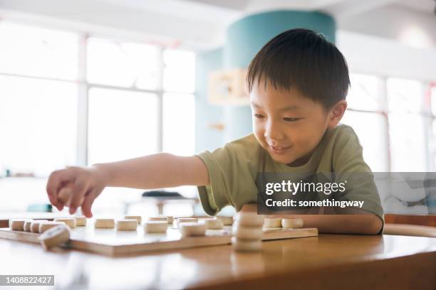 little boy playing chinese chess - china games day 4 imagens e fotografias de stock