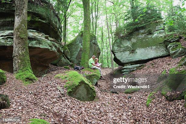 germany, rhineland-palatinate, mature couple reading map in nature park - eifel stock pictures, royalty-free photos & images