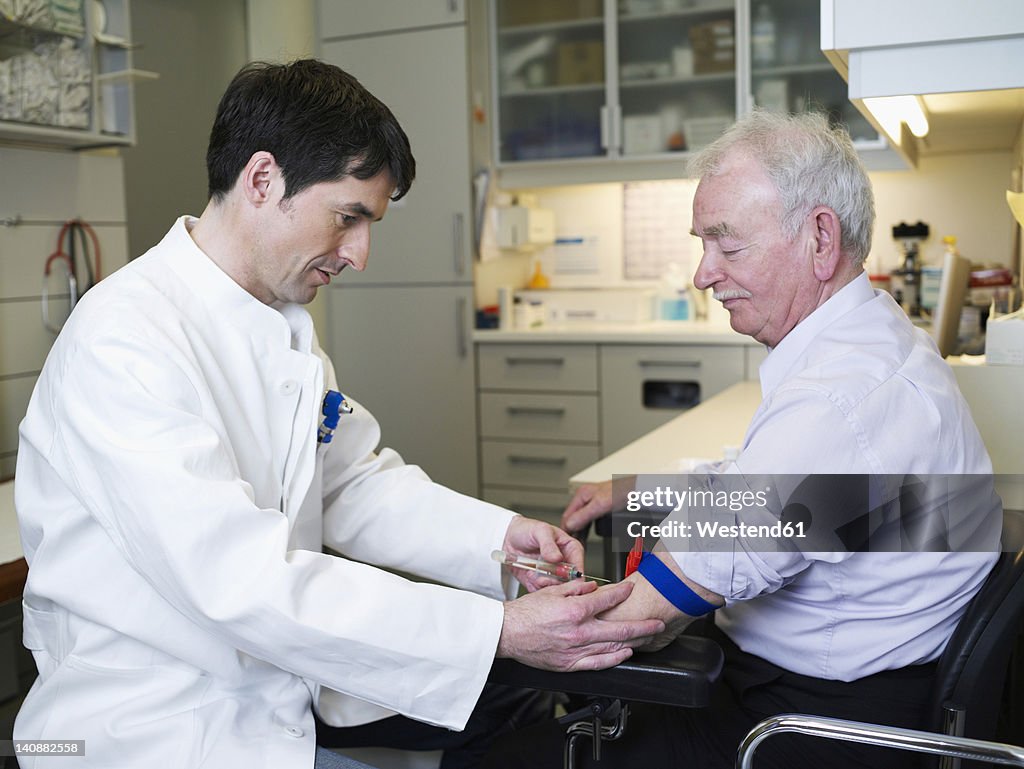 Germany, Hamburg, Doctor injecting patient in clinic