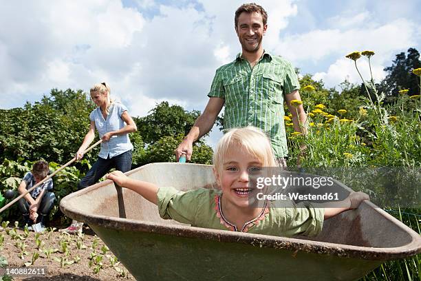 germany, bavaria, altenthann, family gardening together in garden - bavaria girl stockfoto's en -beelden