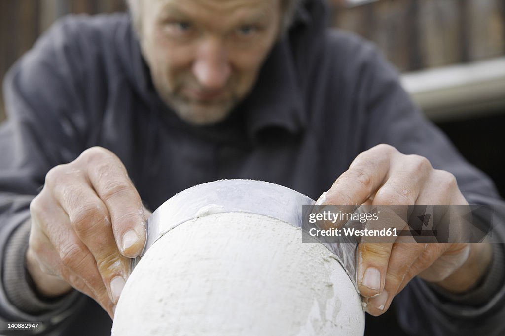 Germany, Upper Bavaria, Munich, Schaeftlarn, Sculptor working with gypsum