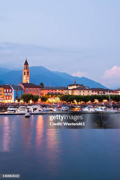 switzerland, ticino, view of ascona at dusk with boats in lake maggiore - アスコナ ストックフォトと画像