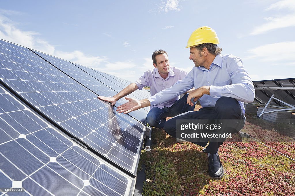 Germany, Munich, Man discussing with engineer in solar plant