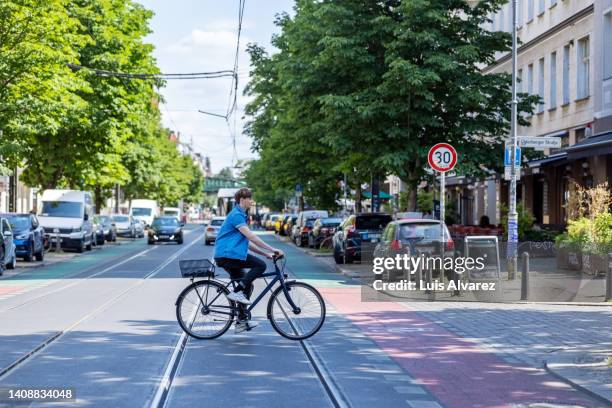 commuter on a bicycle on city street - überqueren stock-fotos und bilder