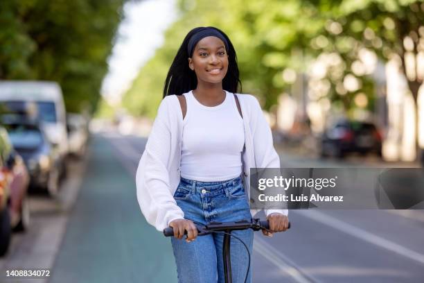 african woman using push scooter for traveling in the city - kosmetisches stirnband stock-fotos und bilder