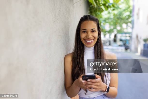 portrait of beautiful african woman with mobile phone and smiling - stylish woman streets europe cellphone stockfoto's en -beelden