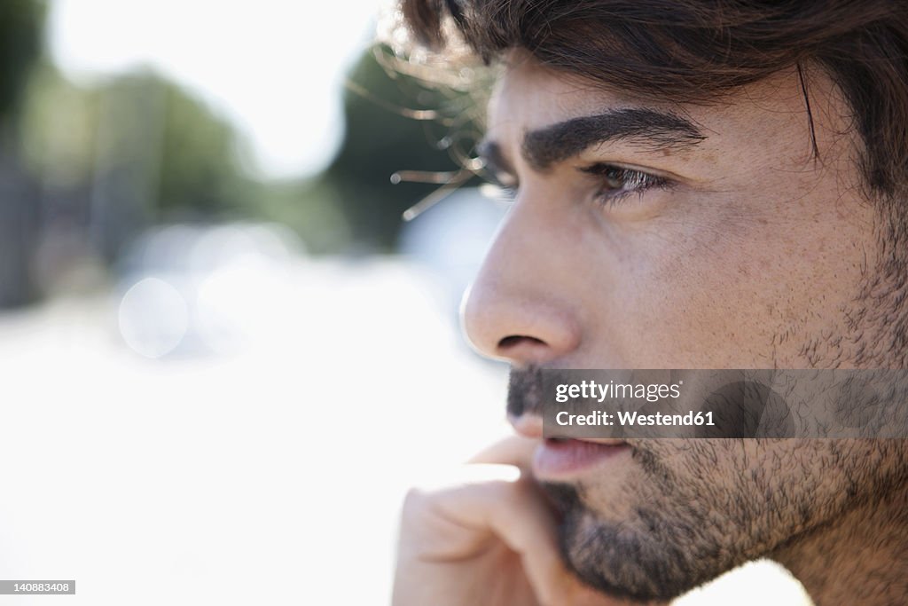 Germany, Cologne, Young man looking away, close up