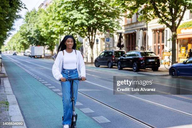 woman commuter riding an electric push scooter - smart city life stock pictures, royalty-free photos & images