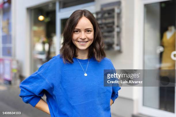 portrait of a beautiful young woman standing on city street - blue tshirt stock pictures, royalty-free photos & images