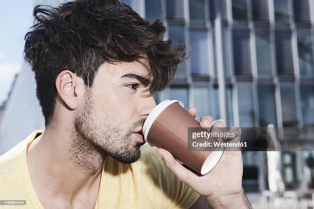 Germany, Cologne, Young man drinking coffee, close up