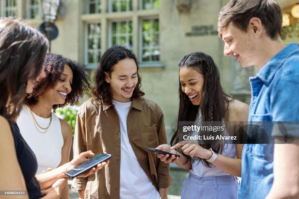Group Checking Group Of Multiethnic Friends Checking Their Smart Phones For Directions ...