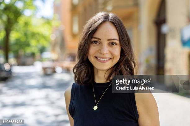 smiling young woman with short hair looking at camera - brunette stockfoto's en -beelden