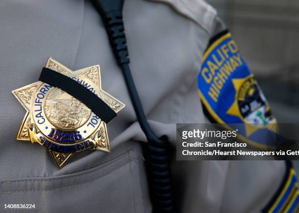 Sgt. Danny Lecce from the Highway Patrol office in Tracy wears a memorial band over his badge at a bell toll tribute ceremony for California Highway...