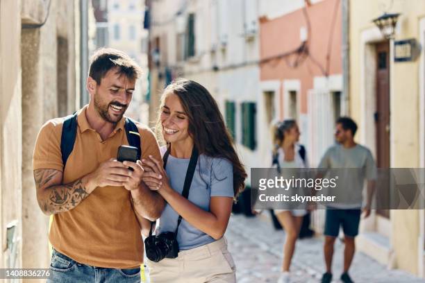 happy tourists using mobile phone on the street. - croatia tourist stock pictures, royalty-free photos & images