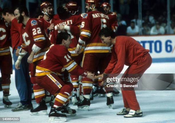 Theoren Fleury of the Calgary Flames celebrates on the ice with teammate Tim Hunter after the Flames defeated the Montreal Canadiens in Game 6 of the...