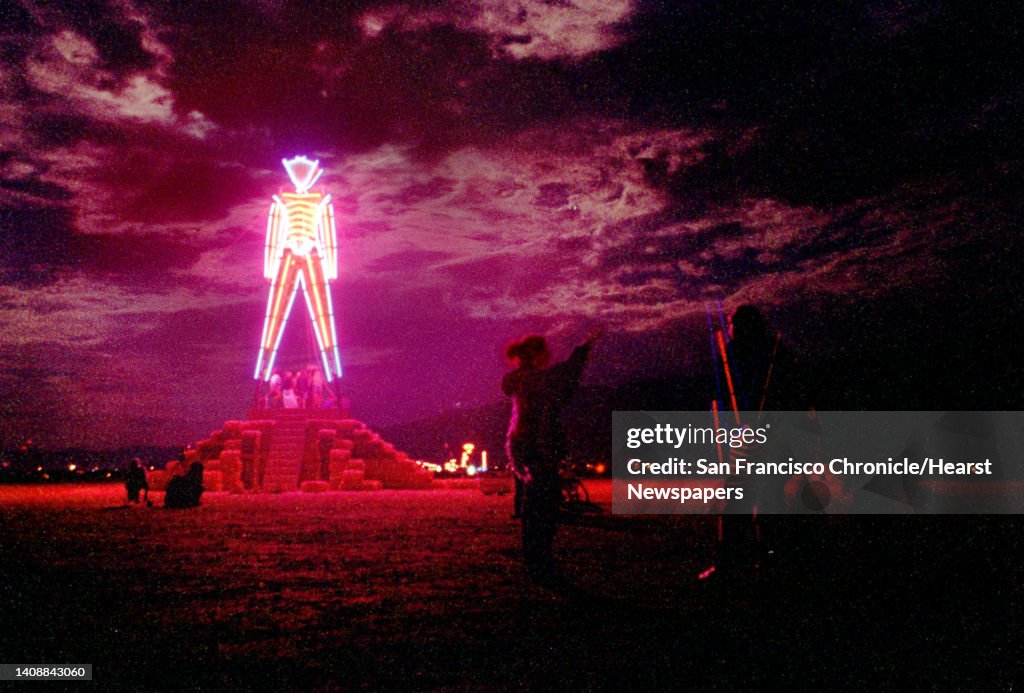 BURNING MAN 03/C/06SEP98/MN/CG --- Lit by neon, the 50-foot-tall Burning Man structure glowed in the early dawn of Sunday, September 6, 1998, just hours before it was set ablaze to conclude the week-long Burning Man Festival in Nevada's Black Rock Desert