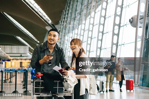 Couple waiting cart luggage trolley at airport. Couple waiting cart luggage trolley at airport.