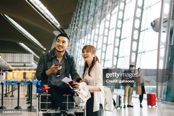 couple waiting cart luggage trolley at airport. - couple airport stock pictures, royalty-free photos & images