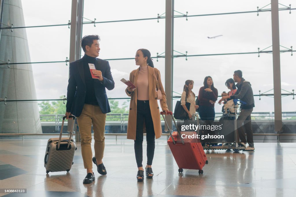 Business person travelling together with suitcases at airport terminal.