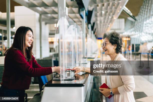 frau, die dem personal am check-in-schalter am flughafen reisepass und ticket übergibt. - id card stock-fotos und bilder