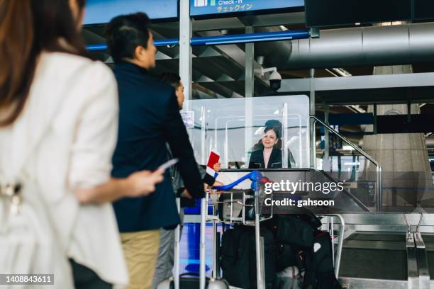 passengers lining up in queue at airport check-in counter. - emigration and immigration 個照片及圖片檔