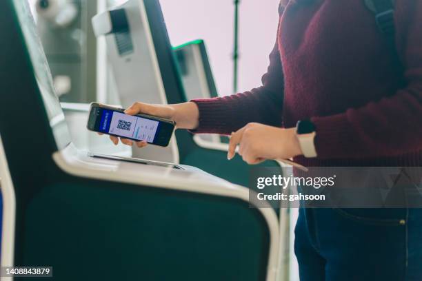 frauen checken im flug mit dem smartphone an einem self-check-in-automaten am flughafen ein - kuala lumpur airport stock-fotos und bilder