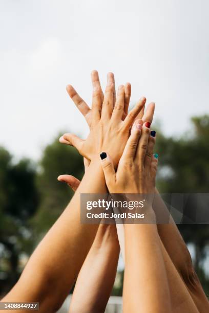 women's hands shaking together on the air - soccer huddle stock pictures, royalty-free photos & images