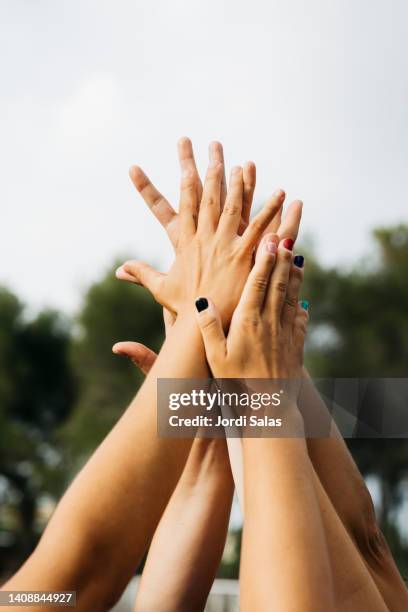 women's hands shaking together on the air - sports team event - fotografias e filmes do acervo