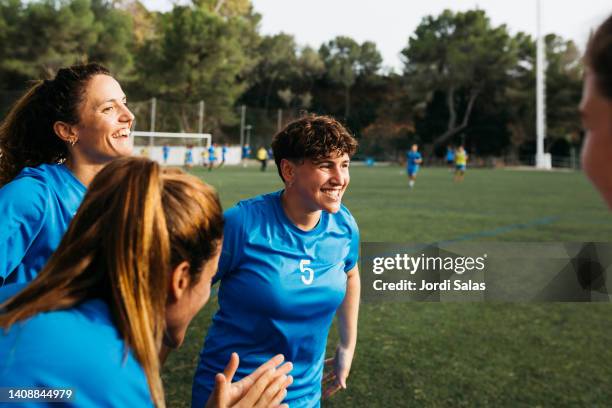female soccer team celebrating a goal - football league stock pictures, royalty-free photos & images