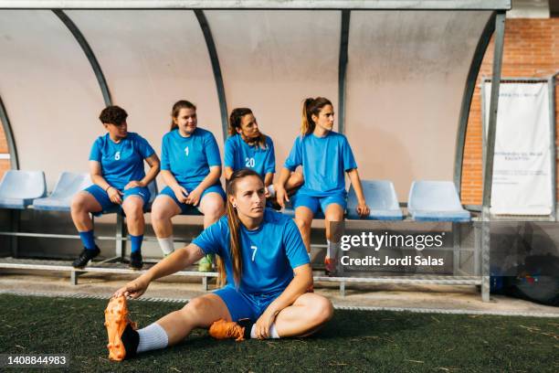 female soccer team on the bench of a field - side lines imagens e fotografias de stock