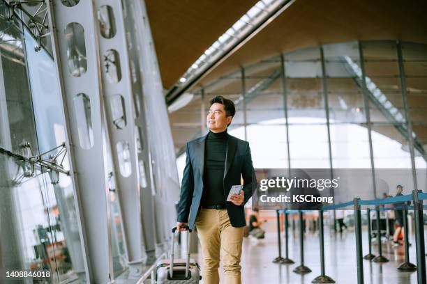 geschäftsmann zu fuß durch den flughafendurchgang - airport asian worker stock-fotos und bilder