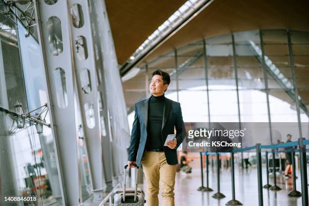 businessman walking through airport passageway - viagem de negócios imagens e fotografias de stock