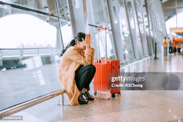 joven asiática molesta y frustrada mientras cancelaba el vuelo en el aeropuerto - cancelación fotografías e imágenes de stock