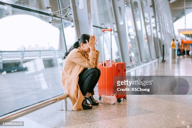une jeune femme asiatique bouleversée et frustrée alors que le vol était annulé à l’aéroport - missing photos et images de collection
