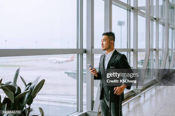 asian businessman at the airport - pressure airplane stock pictures, royalty-free photos & images