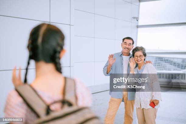 seniorenpaar verabschiedet sich am flughafen - waving hands goodbye stock-fotos und bilder