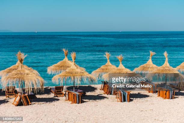 beach umbrella made of straw and sea view - albania stock pictures, royalty-free photos & images