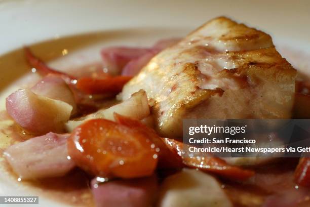 The roast sablefish with jerusalem artichokes and indian red carrots with a little blood orange served at Quince in San Francisco, Ca. Quince is...