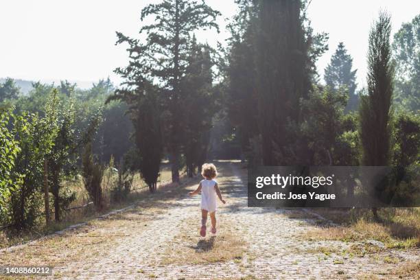 little girl from the back running in nature - guarda sol stock-fotos und bilder