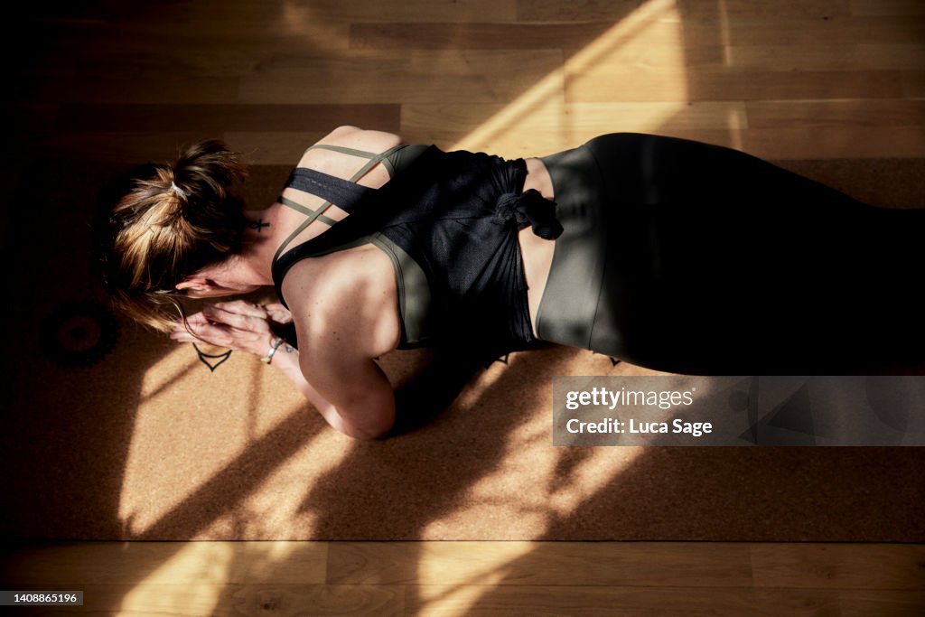 Athletic female in plank pose in a sunny exercise studio